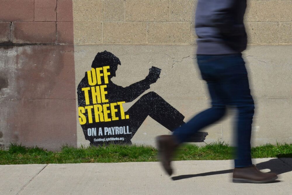 Wall decal of the silhouette of a man with the headline "Off the street. On a payroll"