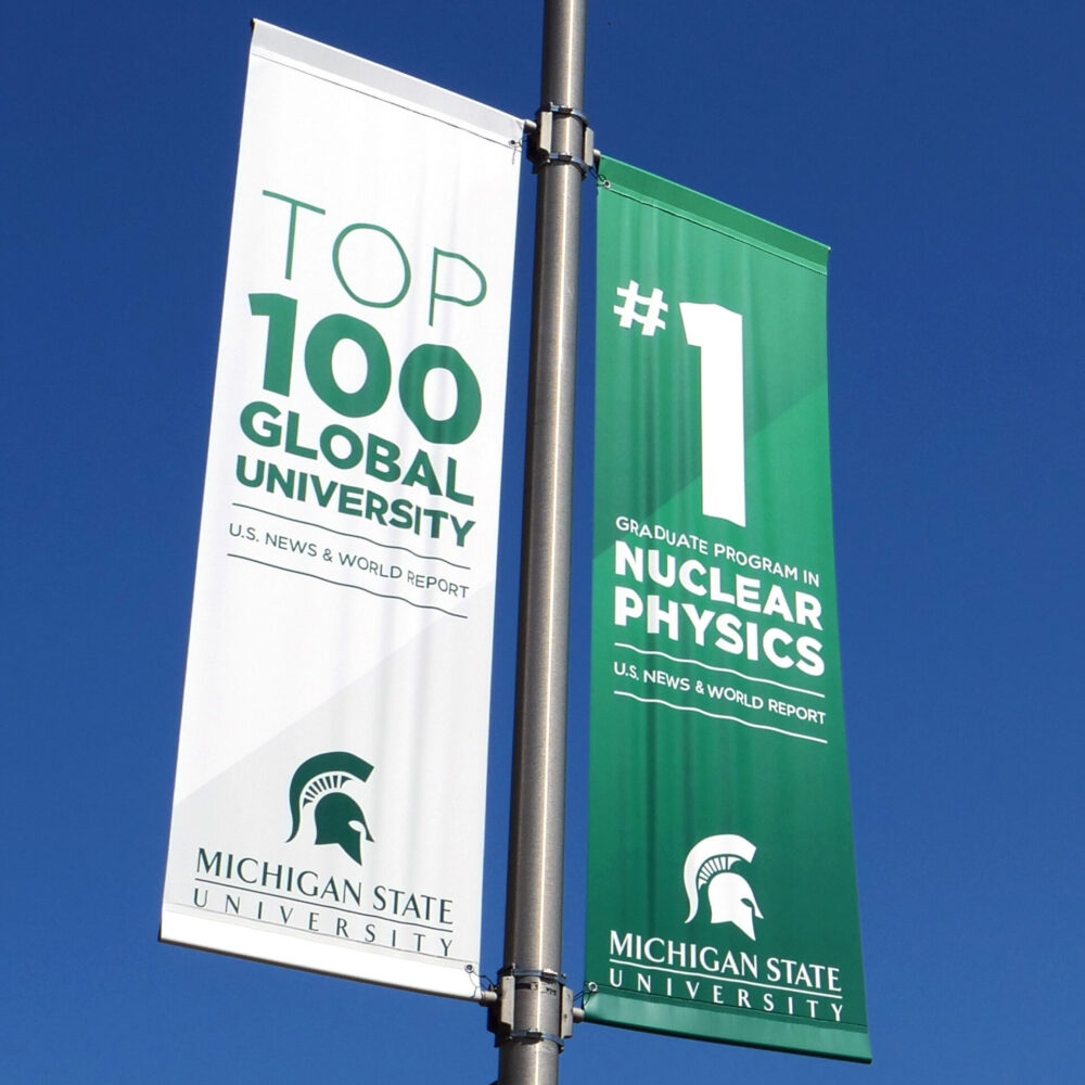 Double street pole banners highlighting various statistics supporting Michigan State University