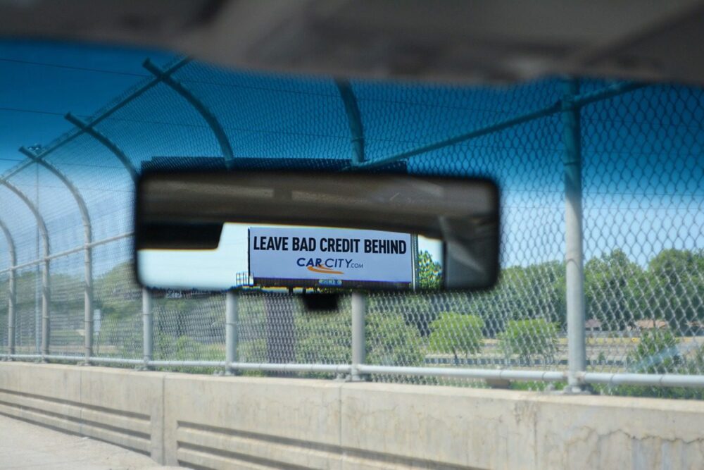 Leave Bad Credit Behind. Car City. Text backwards but shown in rearview mirror so it reads correctly.