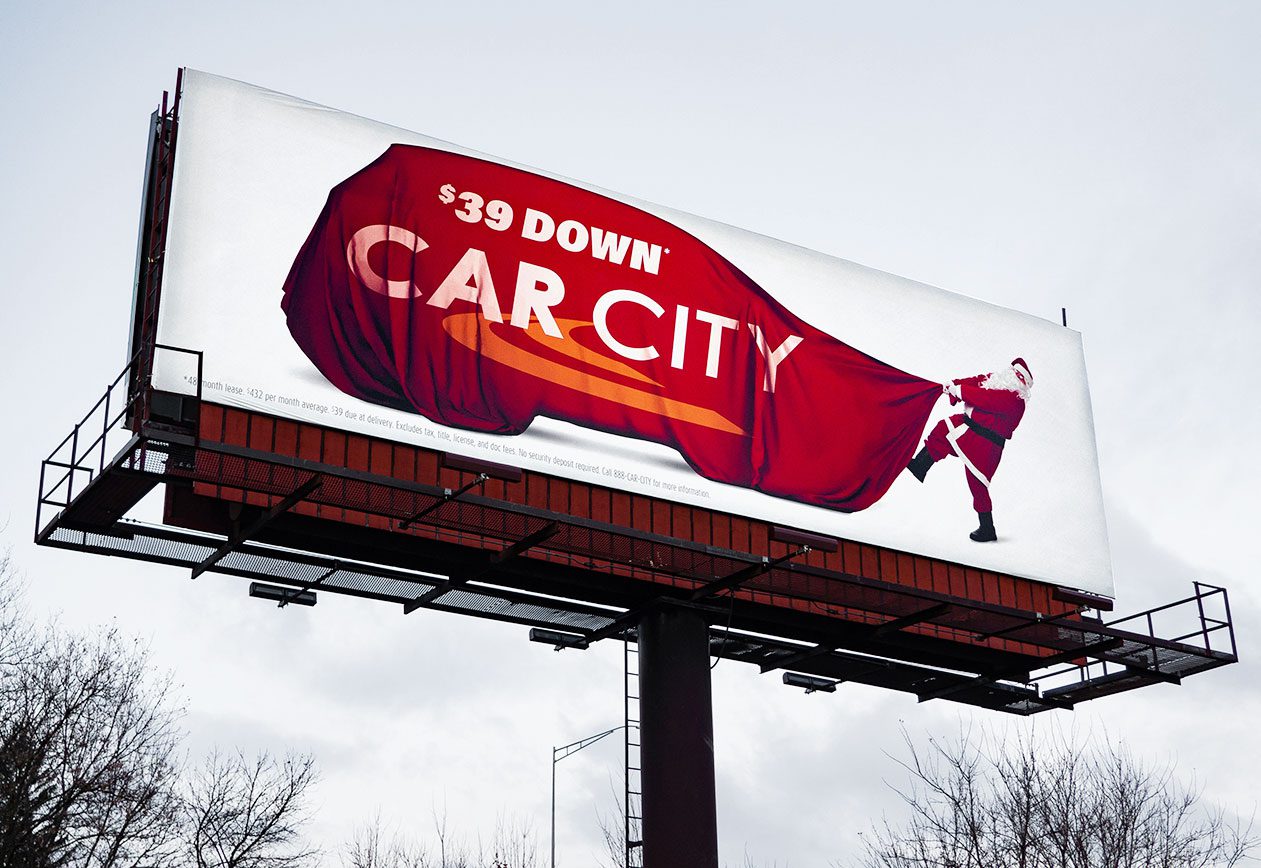 Car City Holiday Bulletin. $39 Down on oversized Santa bag that is shaped like a car. Santa is attempting to pull the bag. 