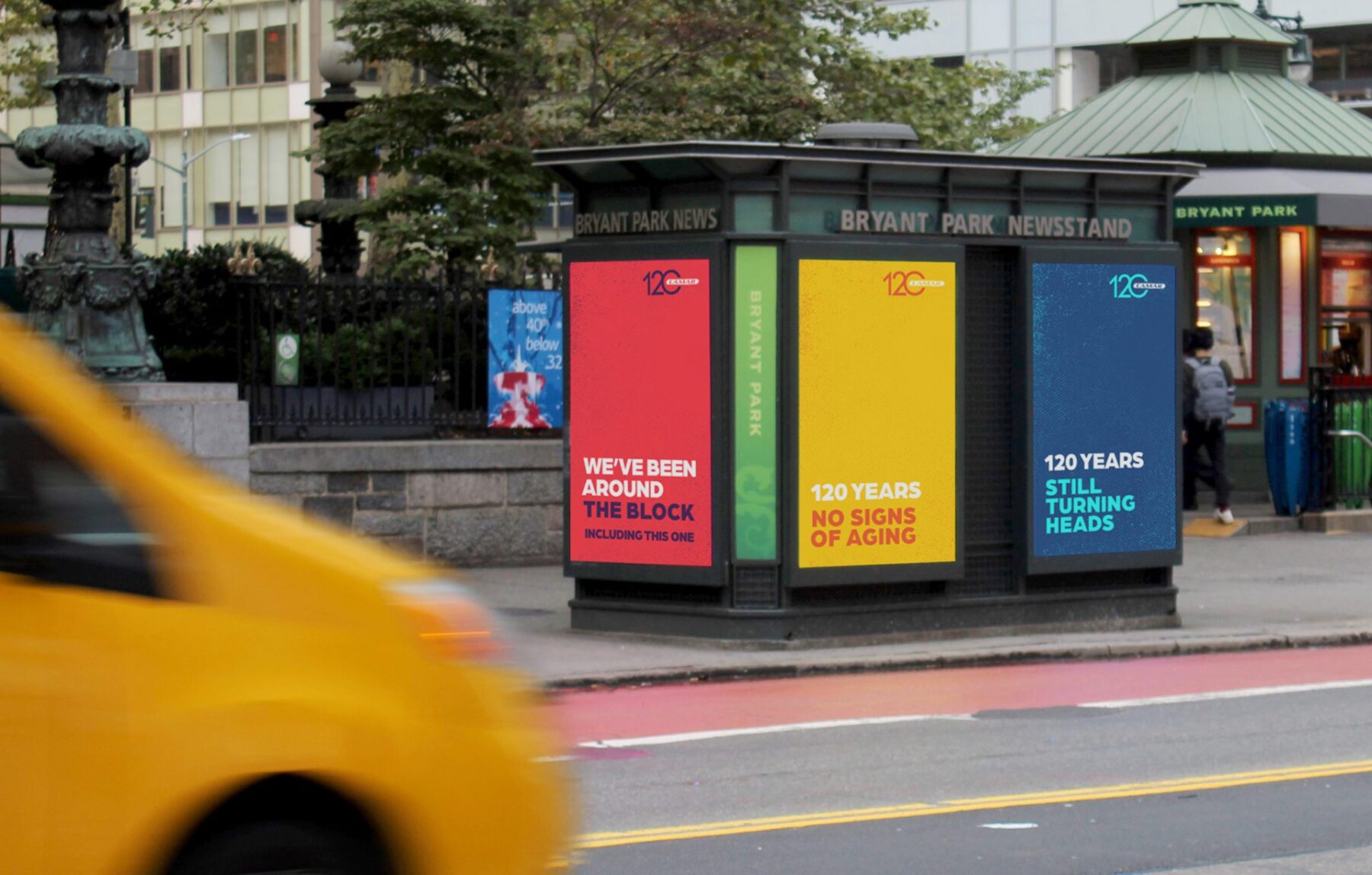 Digital kiosk with 3 screens & 3 posters. "We’ve been around the block.” “120 years no signs of aging.” “120 years still turning heads.”