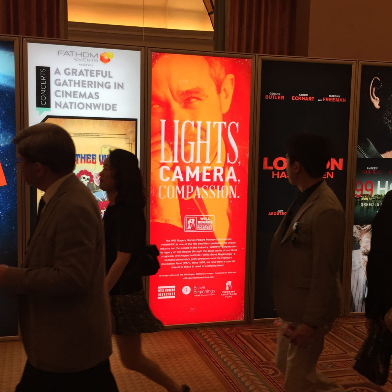 Backlit out of home kiosk with headline "Lights Camera Compassion"