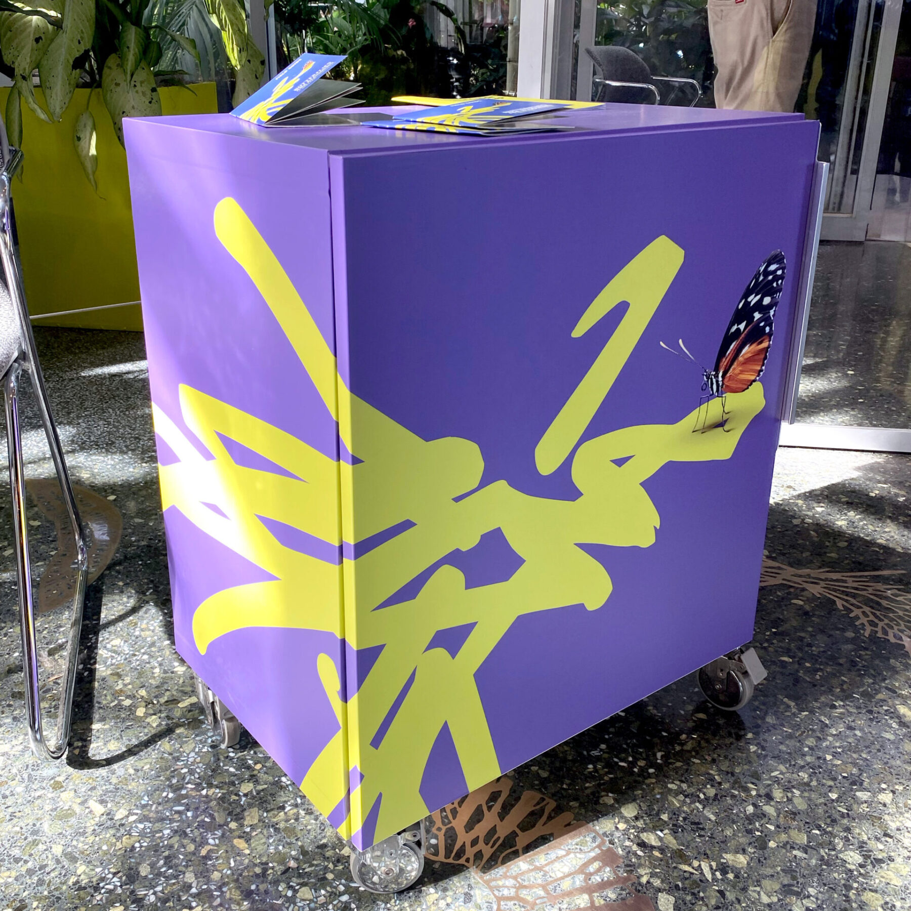 Podium cart wrapped with an illustrated butterfly on the scribble logo for Frederick Meijer Gardens & Sculpture Park.