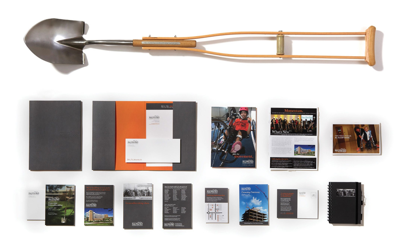 Shovel merged with a crutch for Mary Free Bed's ground breaking ceremony. Also notepads, news pamphlets, cards, maps, & postcards.