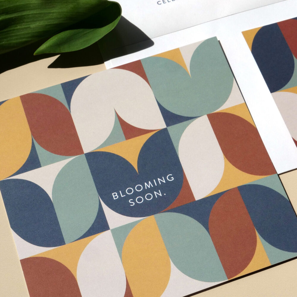 Invite mailer featuring a repeated tulip design with “Blooming Soon.” on the front, and information about the event on the back.