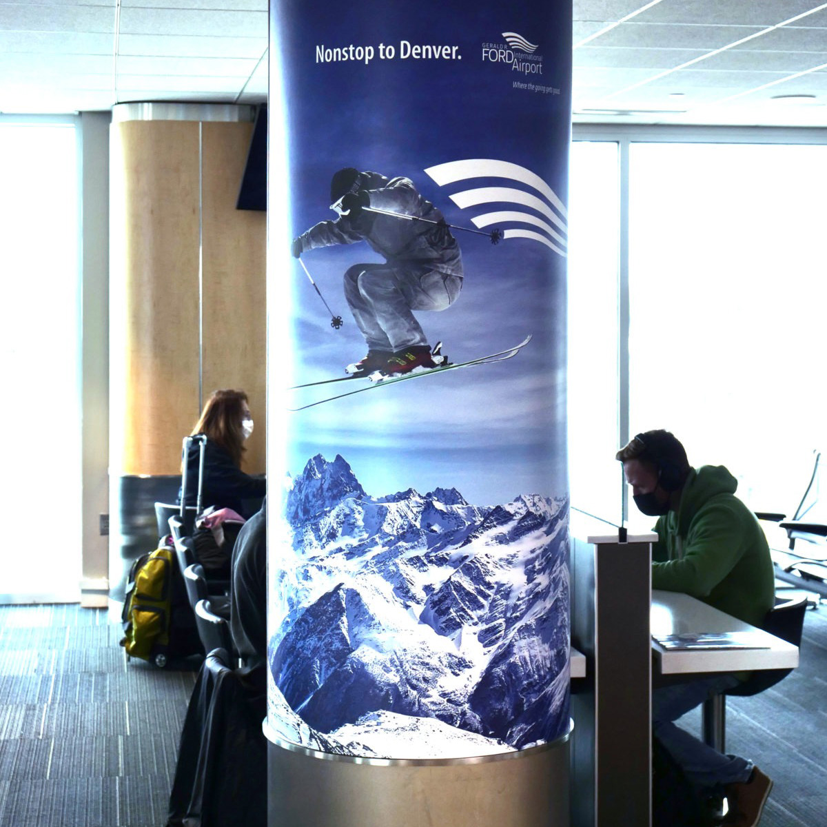 Column wrap with a person skiing over mountains with the line, “nonstop to Denver.”