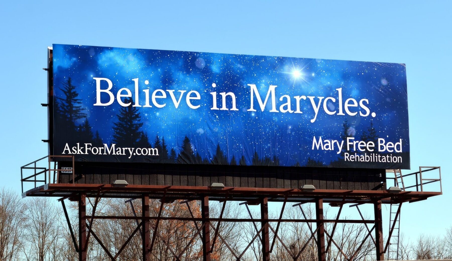 Billboard featuring an image of a starlit sky with falling snow, and the headline “Believe in Marycles.”