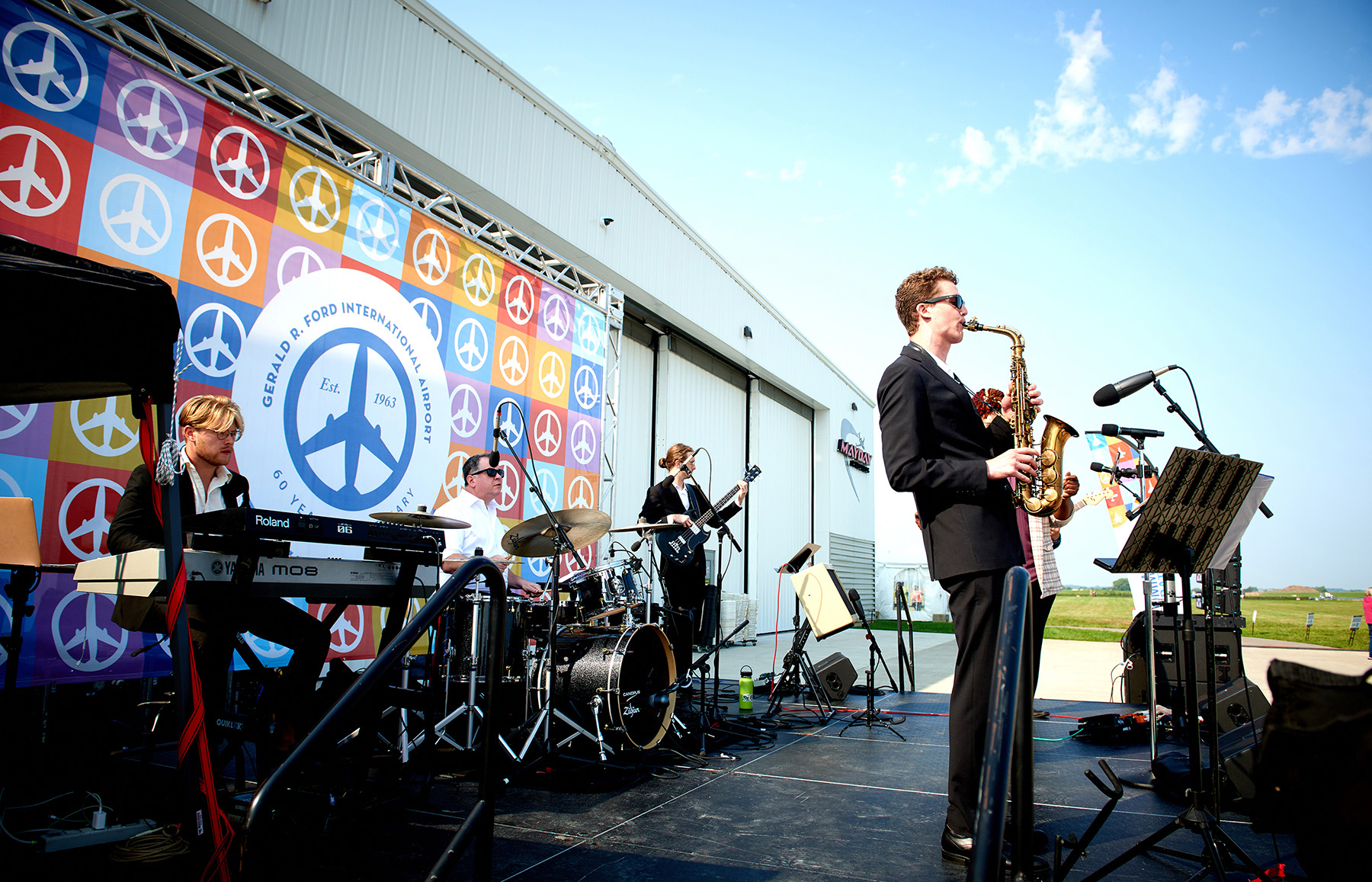 Photograph of performers on a stage in celebration of the 60 year anniversary of Gerald R. Ford International Airport.